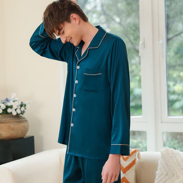 Bộ pijama lụa nam màu xanh cổ vịt tay dài, cổ bẻ viền trắng, người mẫu đứng trong phòng khách