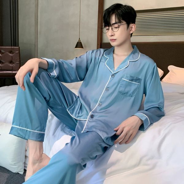 Bộ pijama lụa nam màu xanh dài tay quần dài viền trắng mặc trong phòng ngủ