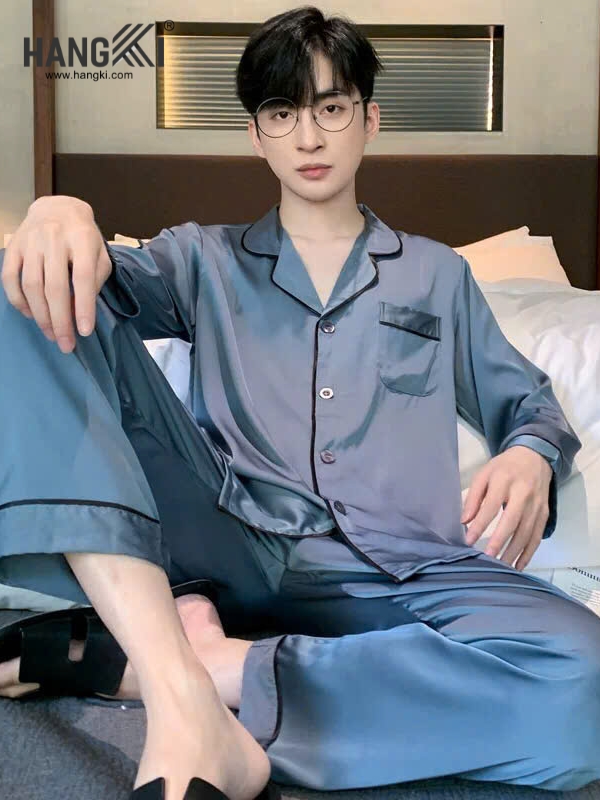 Nam giới mặc bộ pijama lụa xanh tay dài quần dài ngồi trên giường thương hiệu Hangki