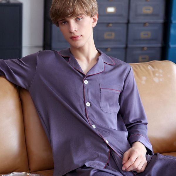 Nam giới mặc bộ pijama lụa màu tím than dài tay ngồi trên ghế sofa