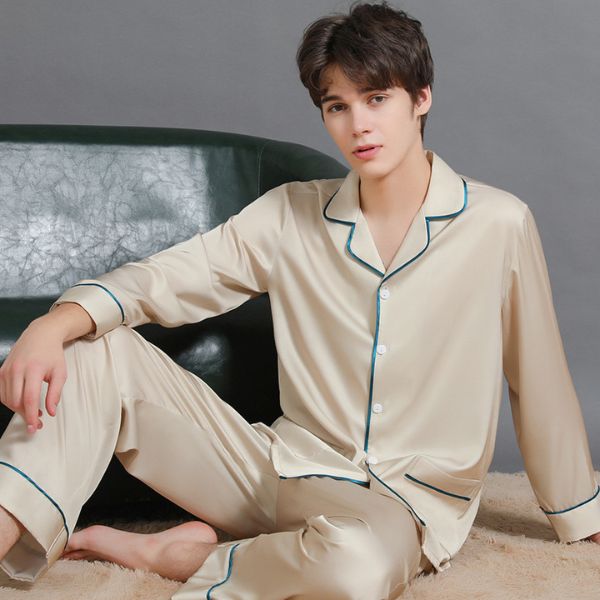 Bộ pijama lụa nam màu kem dài tay quần dài viền xanh ngồi trên ghế da xanh