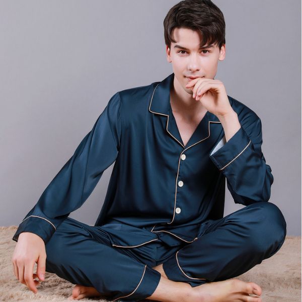 Bộ pijama lụa nam màu xanh đậm dài tay quần dài, dáng rộng thoải mái ngồi trên thảm
