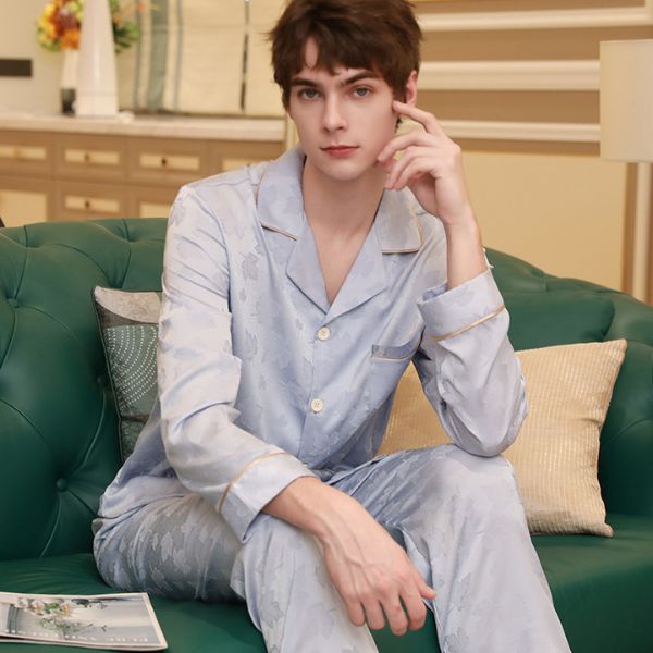 Bộ pijama lụa nam màu xanh nhạt dài tay quần dài ngồi trên ghế sofa trong phòng khách