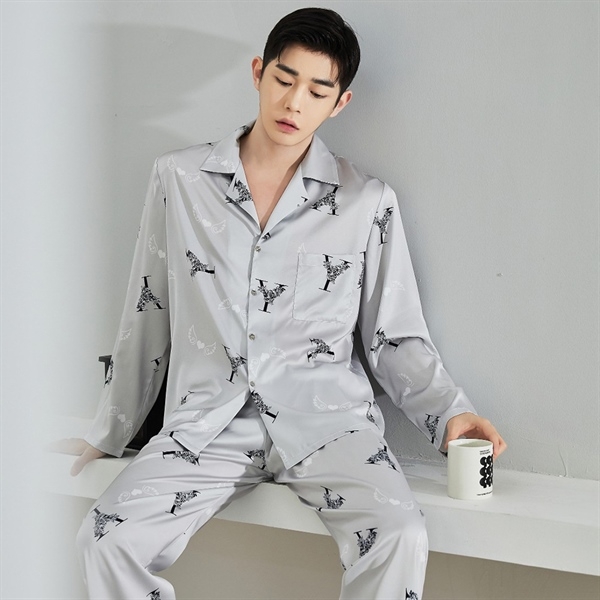 Bộ pijama lụa nam màu xám in họa tiết chữ cái, dáng dài tay quần dài, người mẫu ngồi cầm cốc trắng