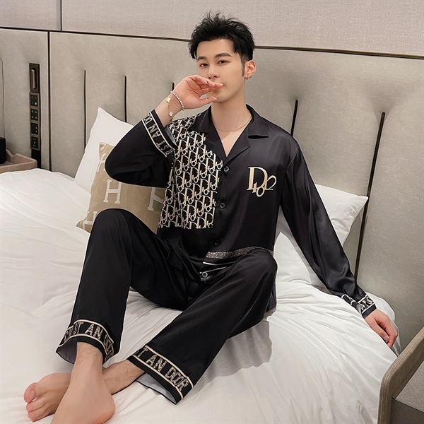 Nam giới mặc bộ pijama lụa đen tay dài họa tiết chữ ngồi trên giường ngủ hiện đại