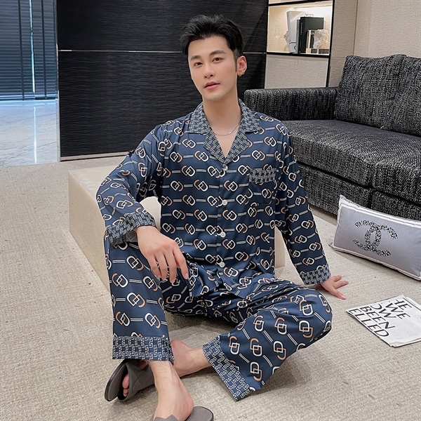 Nam giới mặc bộ pijama lụa dài tay màu xanh họa tiết xích ngồi trên sàn phòng khách hiện đại