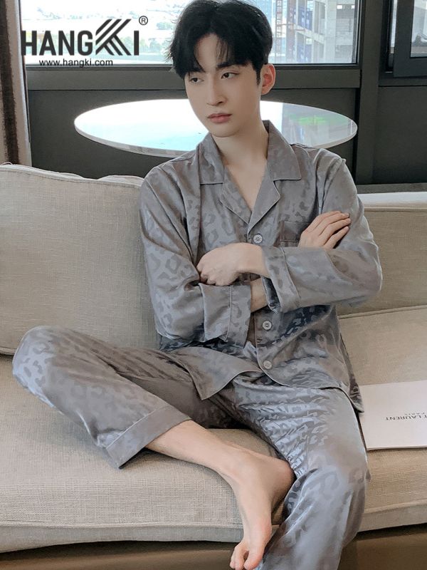 Nam giới mặc bộ pijama lụa xám họa tiết báo của Hangki ngồi trên ghế sofa