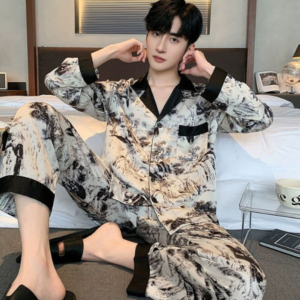 Nam giới mặc bộ pijama lụa họa tiết màu be đen ngồi trên giường trong phòng ngủ hiện đại