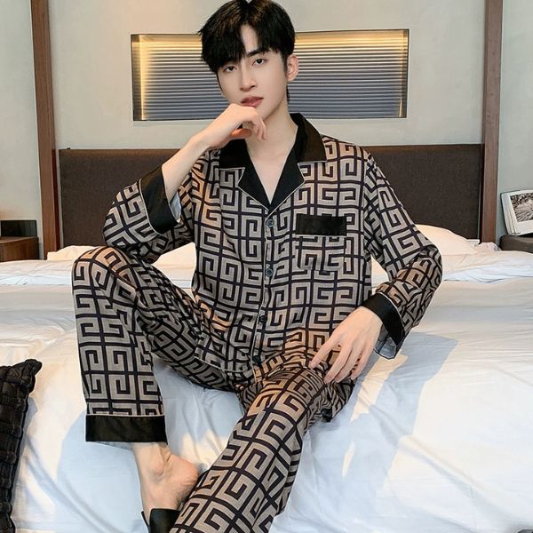 Bộ pijama nam dài tay họa tiết hình học màu nâu đen chất liệu lụa ngồi trên giường ngủ