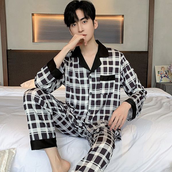Bộ pijama nam dài tay kẻ caro đen trắng chất lụa bóng ngồi trên giường ngủ