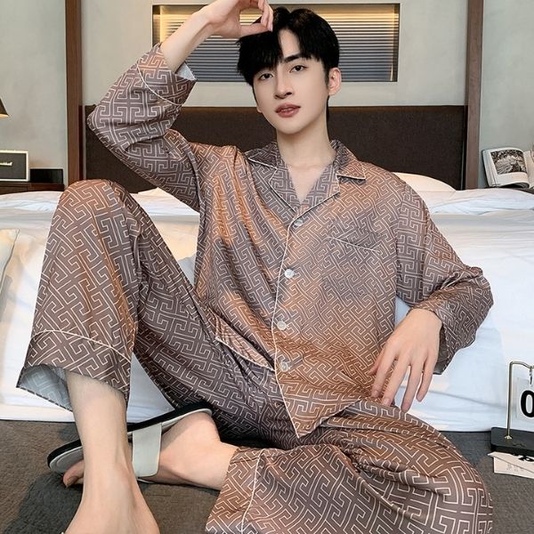 Nam giới mặc bộ pijama lụa dài tay họa tiết hình học màu nâu ngồi trên giường ngủ