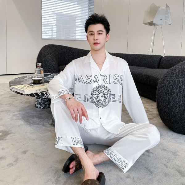 Bộ đồ ngủ nam màu trắng chữ VASARISE chất liệu mỏng nhẹ, người mẫu ngồi trong phòng khách hiện đại