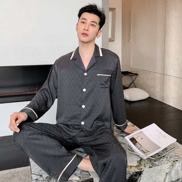 Nam giới mặc bộ pijama lụa màu xám đậm dài tay ngồi thư giãn trong phòng ngủ hiện đại
