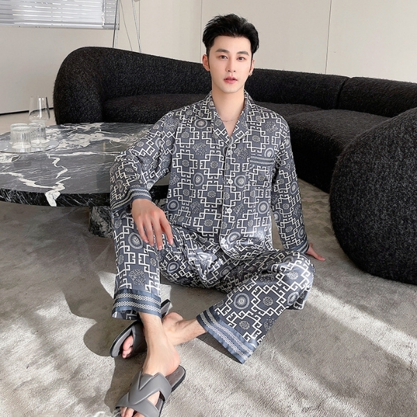 Nam giới mặc bộ pijama lụa họa tiết hình học màu xám ngồi trên thảm phòng khách hiện đại