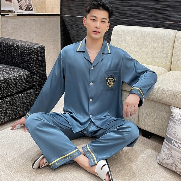 Bộ pijama lụa nam màu xanh dài tay quần dài, cổ bẻ, ngồi trên ghế sofa trong phòng khách