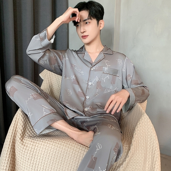 Bộ pijama lụa nam màu xám họa tiết chữ, dáng dài tay quần dài, người mẫu ngồi trên ghế vải mềm