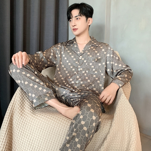 Nam giới mặc bộ pijama lụa dài tay họa tiết tròn màu xám ngồi trên ghế vải sáng màu