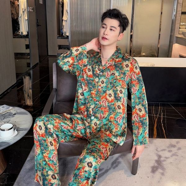 Nam giới mặc bộ pijama lụa họa tiết hoa nhiều màu ngồi trên ghế sofa trong phòng khách hiện đại