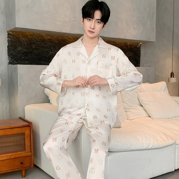 Bộ pijama lụa nam màu kem họa tiết chữ cái, dáng rộng dài tay quần dài ngồi trên sofa