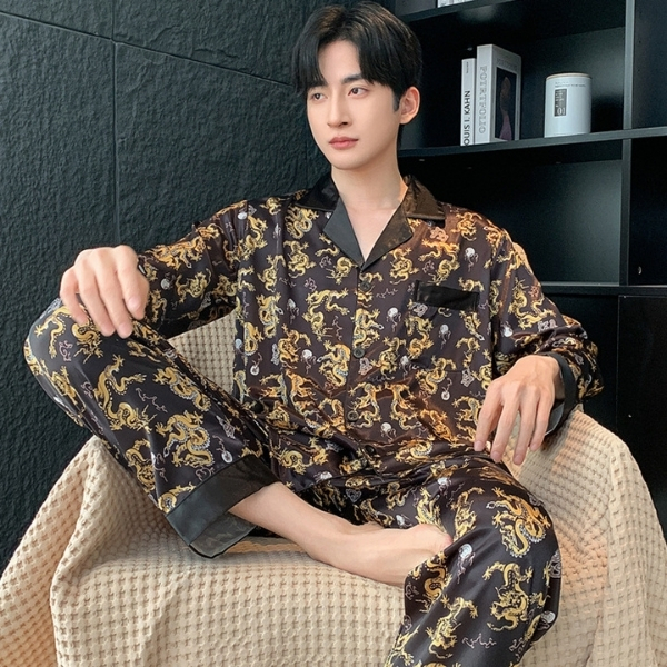 Bộ pijama lụa nam màu đen họa tiết rồng vàng dáng dài tay quần dài ngồi trên ghế sofa