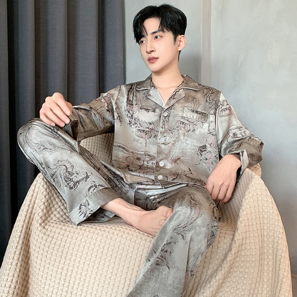 Nam giới mặc bộ pijama lụa dài tay họa tiết màu xám ngồi trên ghế vải màu be