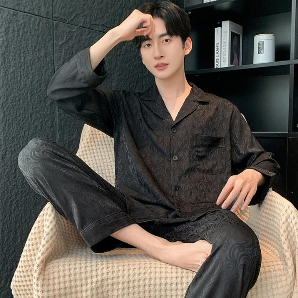 Bộ pijama lụa nam màu đen họa tiết sang trọng, dáng dài tay quần dài, người mẫu ngồi trên ghế sofa