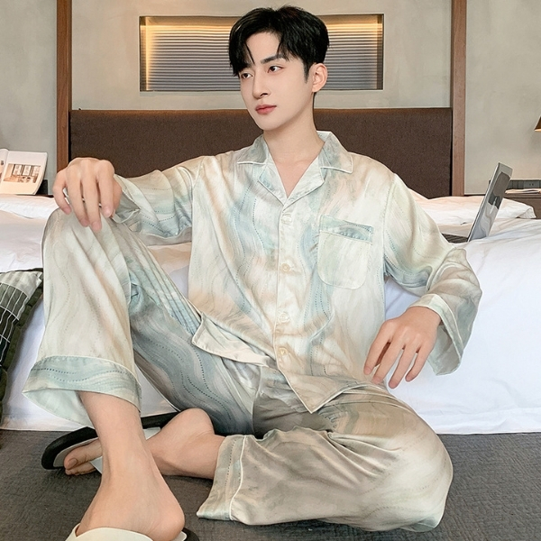 Bộ pijama lụa nam dài tay màu pastel họa tiết loang, người mẫu ngồi trên giường trong phòng ngủ