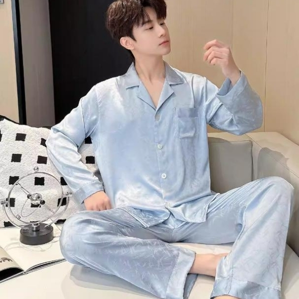 Nam giới mặc bộ pijama lụa màu xanh nhạt dài tay quần dài ngồi trên sofa trong phòng ngủ