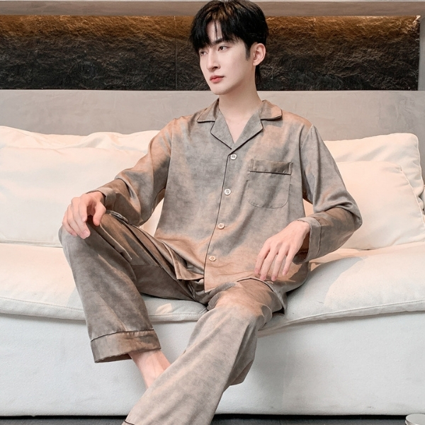 Bộ pijama lụa dài tay màu be cho nam ngồi trên sofa trắng