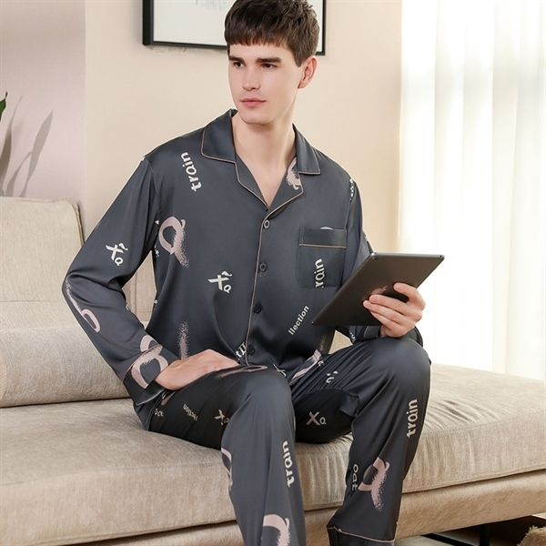Bộ pijama lụa nam màu xám dài tay quần dài họa tiết chữ ngồi trên sofa cầm máy tính bảng