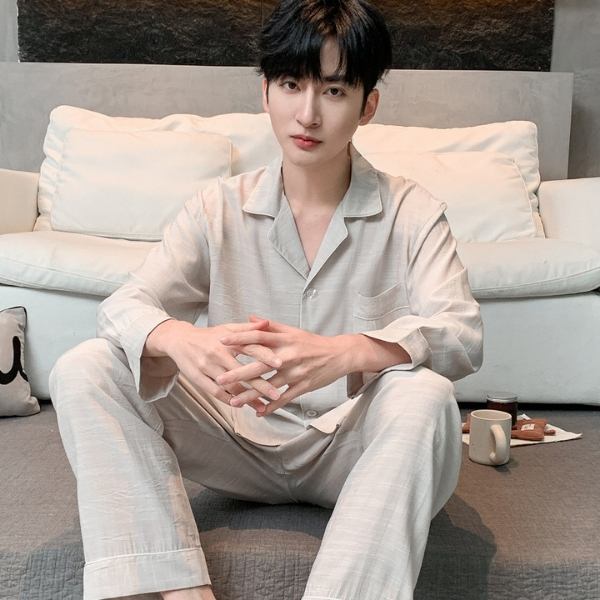 Nam giới mặc bộ pijama lụa màu be dài tay quần dài ngồi trên ghế sofa trong phòng khách