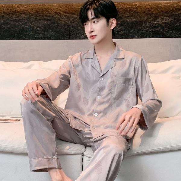 Bộ pijama lụa dài tay màu be cho nam, thiết kế cổ bẻ và quần dài ngồi trên ghế sofa