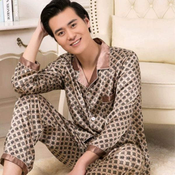 Bộ pijama lụa nam dài tay họa tiết caro màu nâu be người mẫu ngồi trên ghế sofa