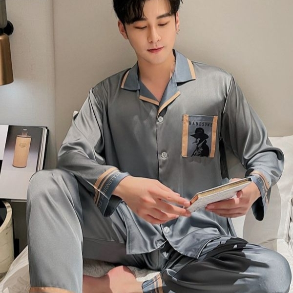 Nam giới mặc bộ pijama lụa màu xám dài tay ngồi trên giường đọc sách