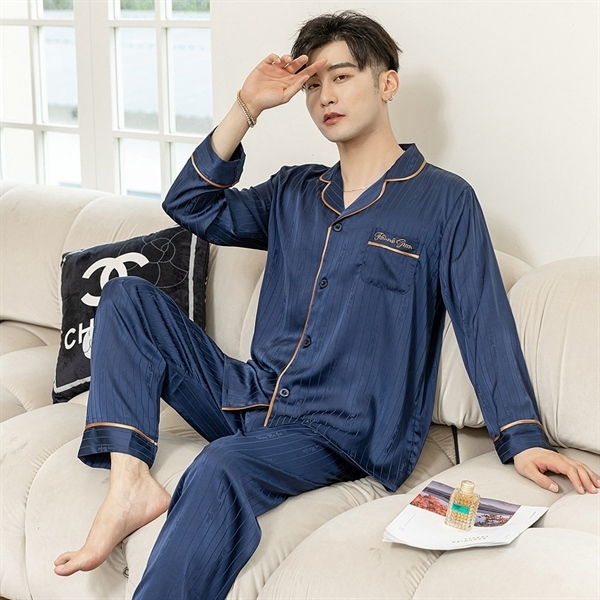 Nam giới mặc bộ pijama lụa dài tay màu xanh navy ngồi trên ghế sofa trong phòng khách