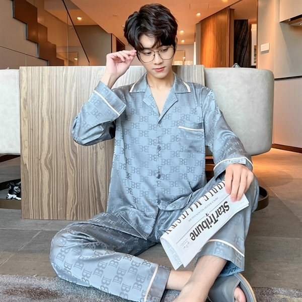 Nam giới mặc bộ pijama lụa màu xám tay dài quần dài họa tiết chữ ngồi đọc báo trong phòng ngủ