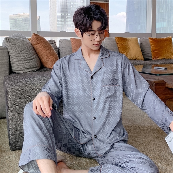 Bộ pijama lụa nam màu xám họa tiết hình học dài tay quần dài ngồi trên sofa phòng khách hiện đại