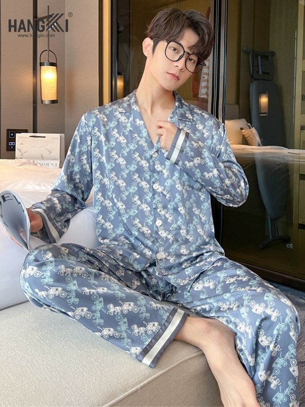 Nam giới mặc bộ pijama lụa màu xanh họa tiết xe đạp ngồi trên giường trong phòng ngủ hiện đại