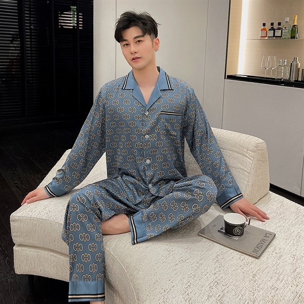 Bộ pijama lụa nam màu xanh họa tiết hoa văn, dáng dài tay quần dài, người mẫu ngồi trên sofa
