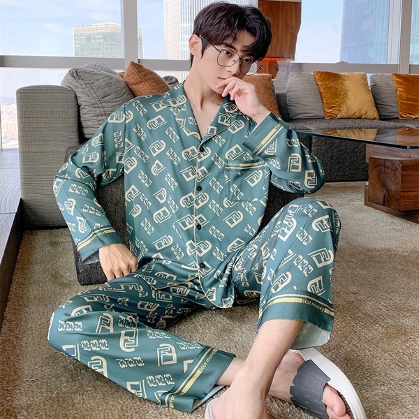 Bộ pijama lụa nam màu xanh họa tiết chữ, dáng dài tay quần dài, người mẫu ngồi trên sofa trong phòng khách
