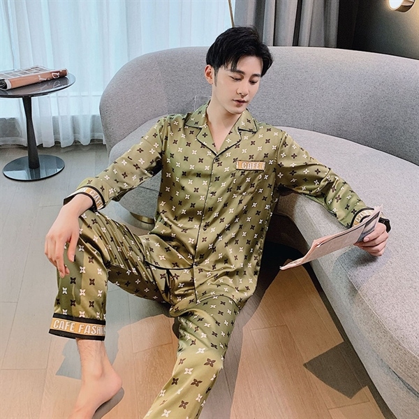 Bộ pijama lụa nam màu xanh họa tiết sao, tay dài quần dài, người mẫu ngồi trên sofa đọc tạp chí