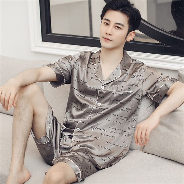 Bộ đồ ngủ nam lụa satin ngắn tay màu xám in chữ, dáng rộng thoải mái ngồi trên sofa