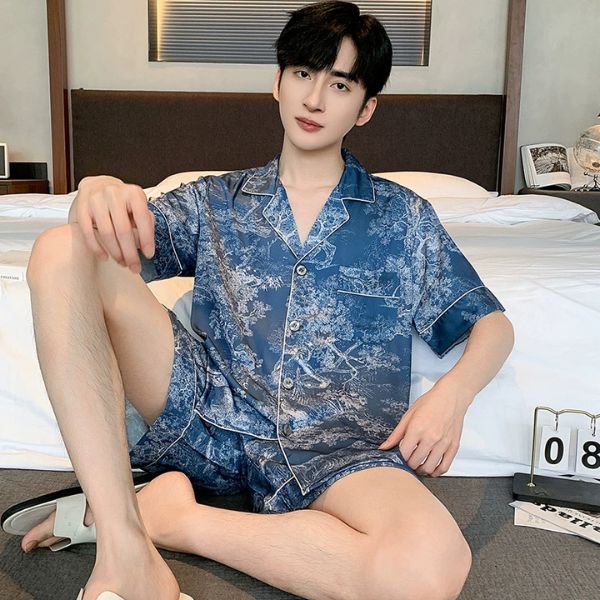 Nam giới mặc bộ đồ ngủ lụa ngắn tay màu xanh họa tiết ngồi trên giường trong phòng ngủ