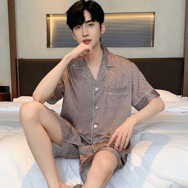 Bộ đồ ngủ nam tay ngắn họa tiết hình học màu nâu nhạt chất liệu mỏng nhẹ ngồi trên giường