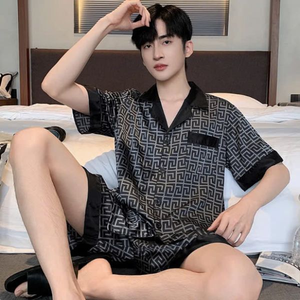 Bộ đồ ngủ nam lụa ngắn tay màu đen họa tiết hình học ngồi trên giường trong phòng ngủ