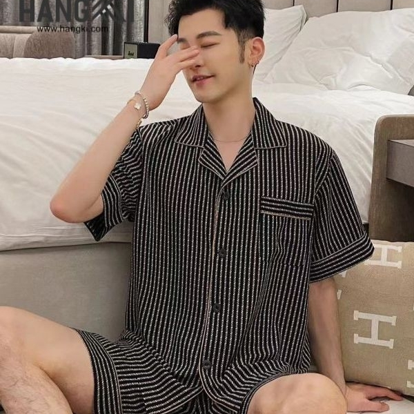 Bộ đồ ngủ nam tay ngắn kẻ sọc đen trắng chất liệu mỏng nhẹ ngồi trên giường