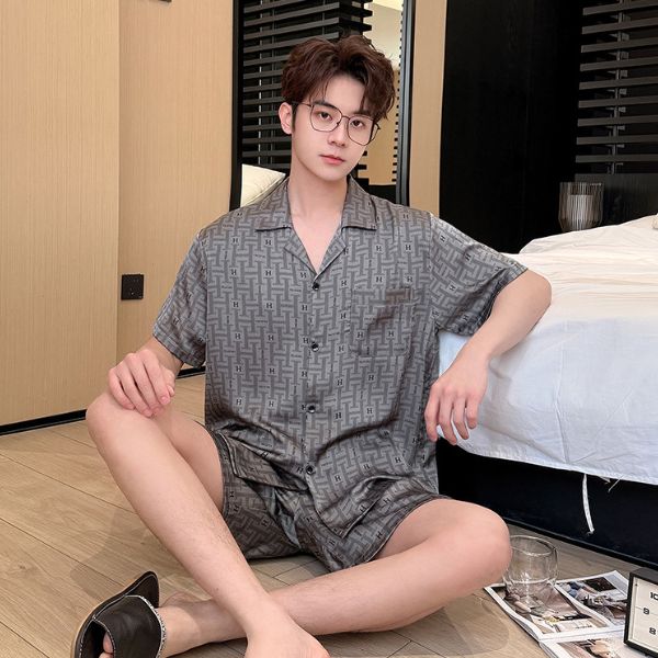 Nam giới mặc bộ đồ ngủ lụa ngắn tay màu xám họa tiết ngồi trên sàn cạnh giường ngủ