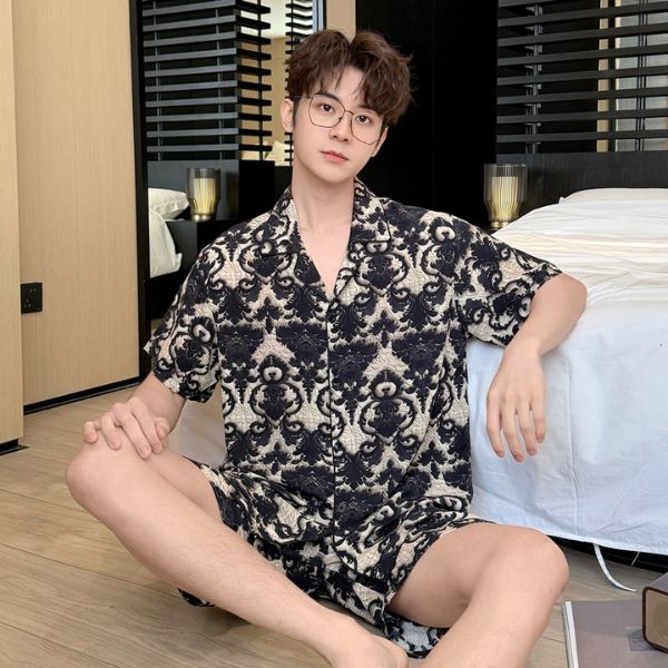Nam giới mặc bộ đồ ngủ họa tiết đen trắng ngồi trên sàn phòng ngủ hiện đại