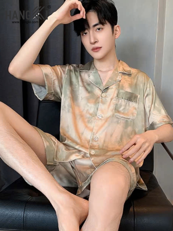 Nam giới mặc bộ pijama lụa ngắn tay màu loang ngồi trên ghế da màu đen