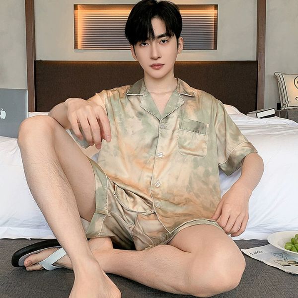 Nam giới mặc bộ đồ ngủ lụa tay ngắn màu loang ngồi trên giường trong phòng ngủ hiện đại